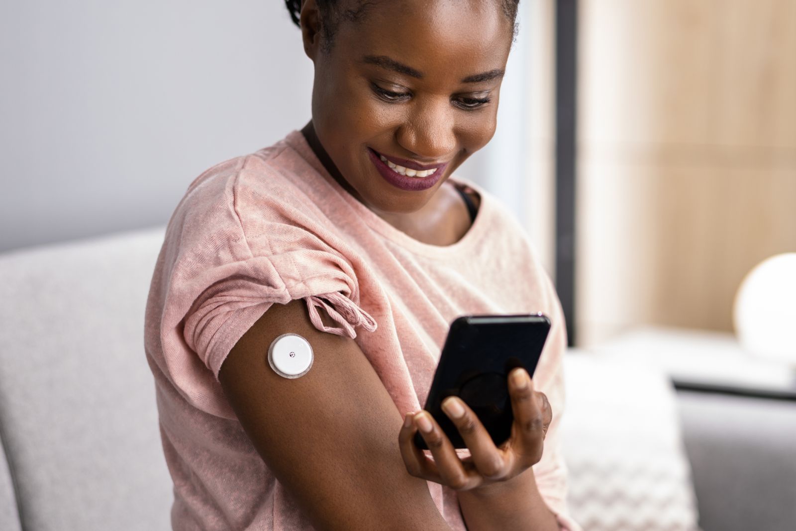 A person with diabetes checks her blood sugar using a CGM