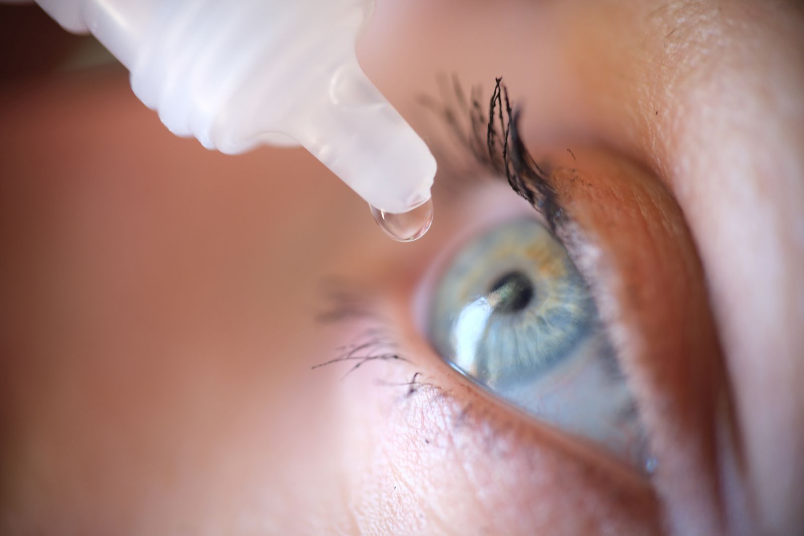 A person receives eye drop treatment