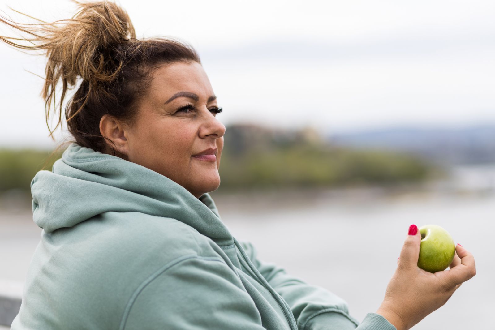 A person with obesity eats an apple