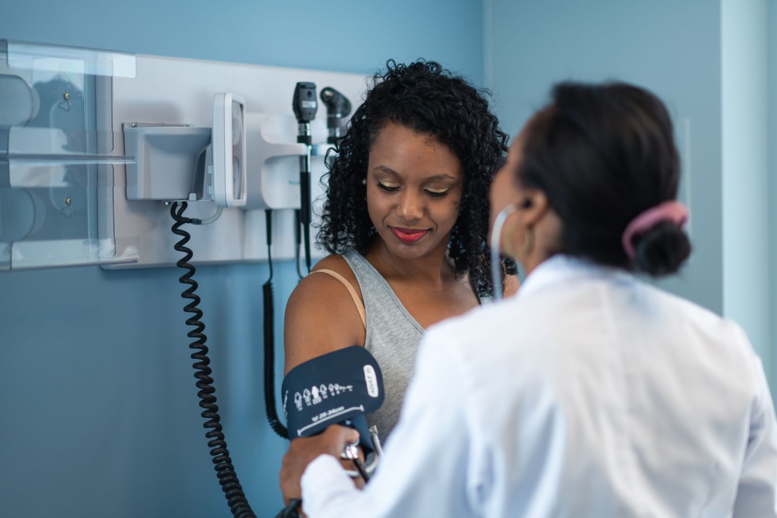 A doctor performs a blood pressure screening for a person with diabetes