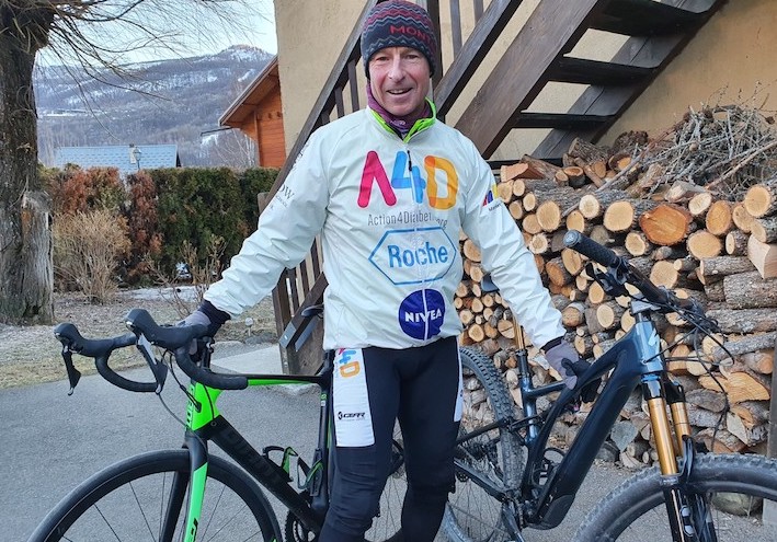 Cyclist wearing brightly colored shirt holding a mountain bike and road bike