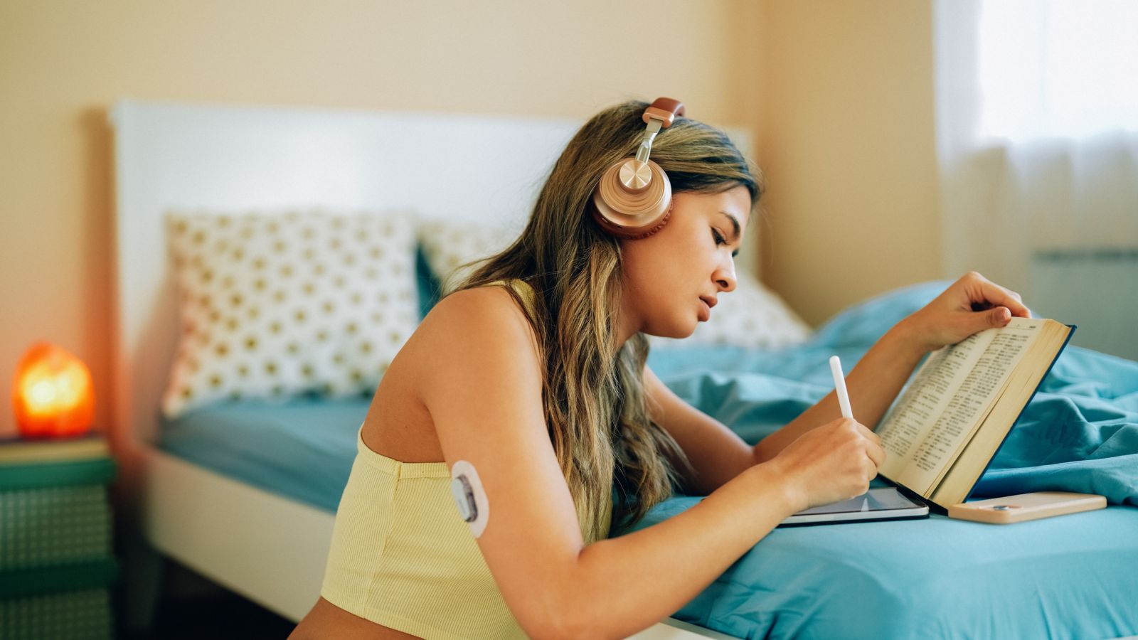 A woman with diabetes wears a CGM as she journals