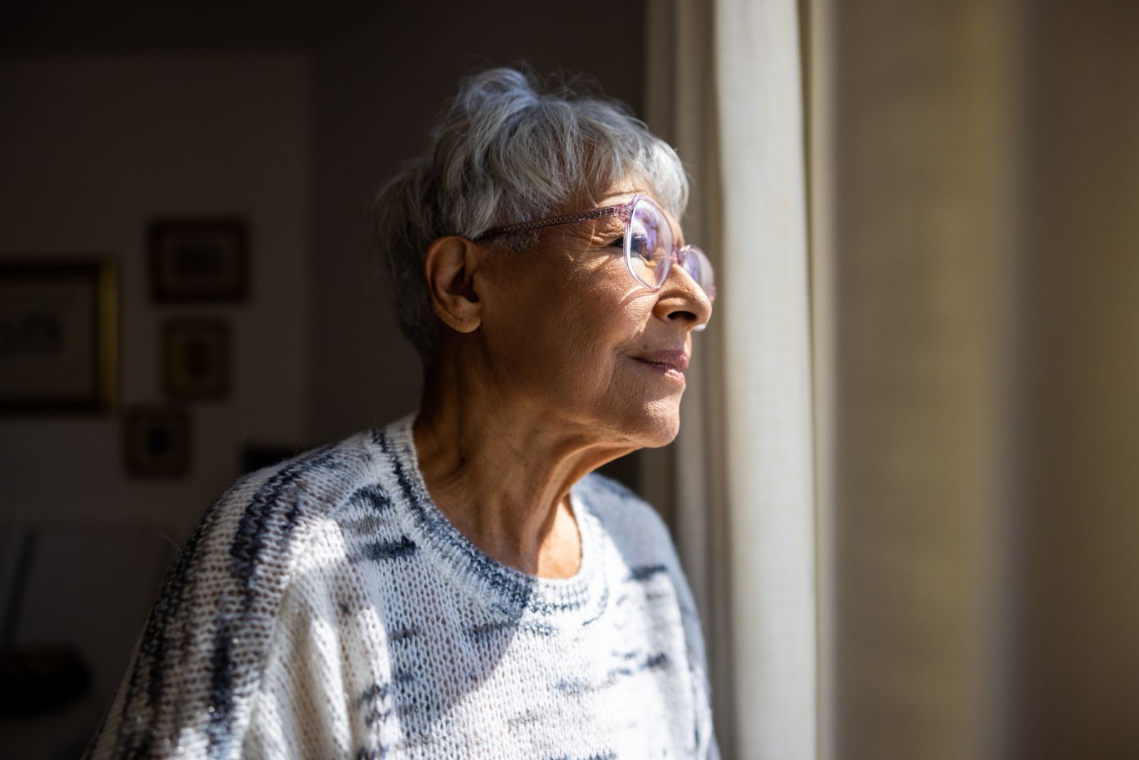 older woman looking out window