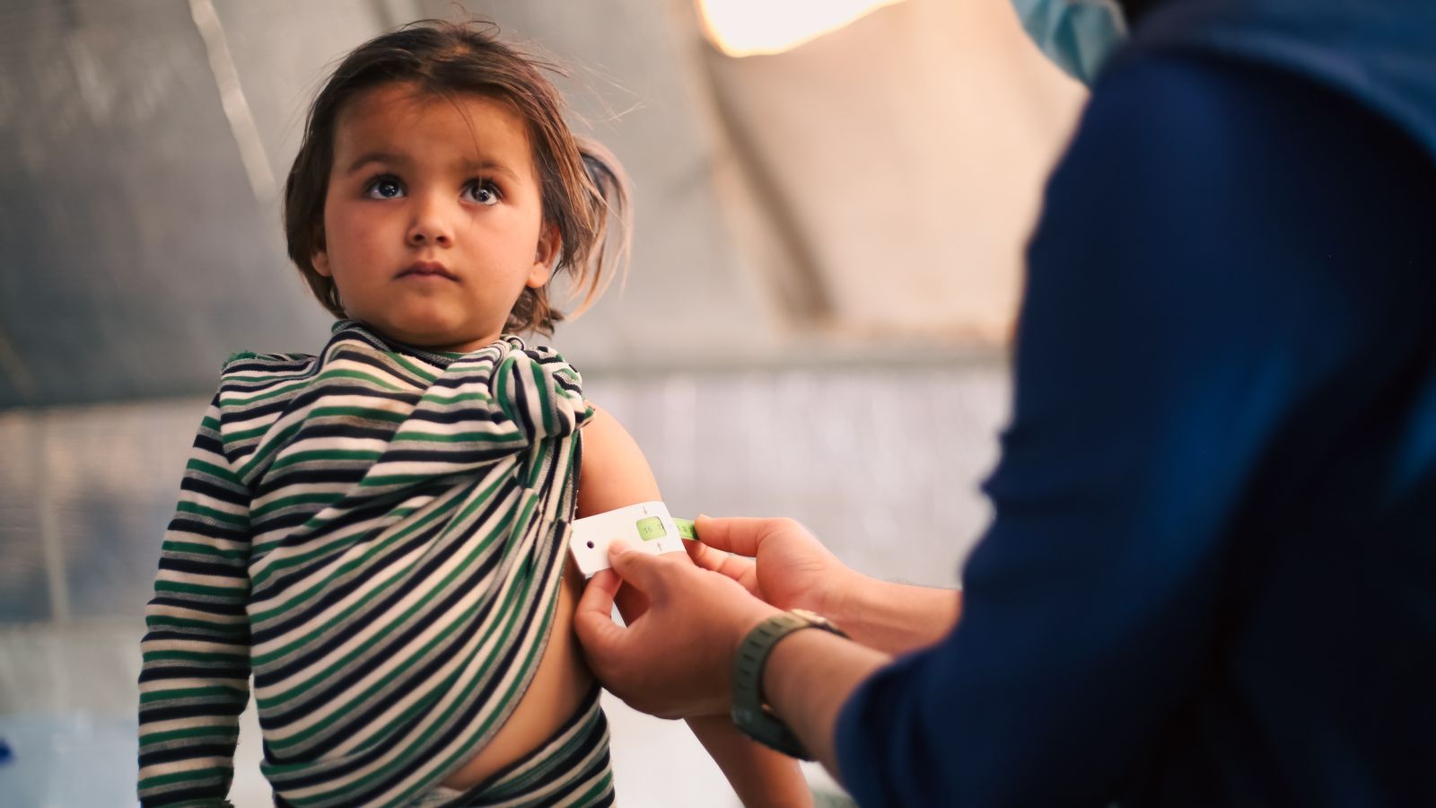 Doctor examines child in refugee camp