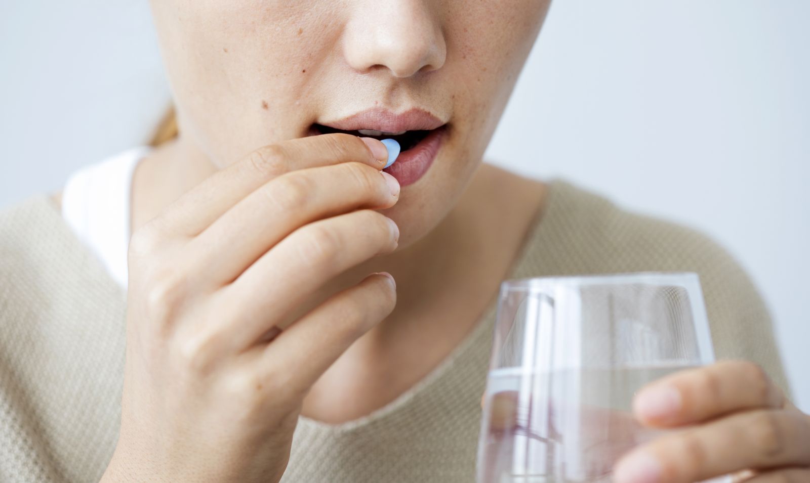 A woman takes a pill for diabetes