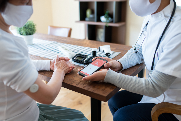 Two people sitting at a table talking about automated insulin delivery