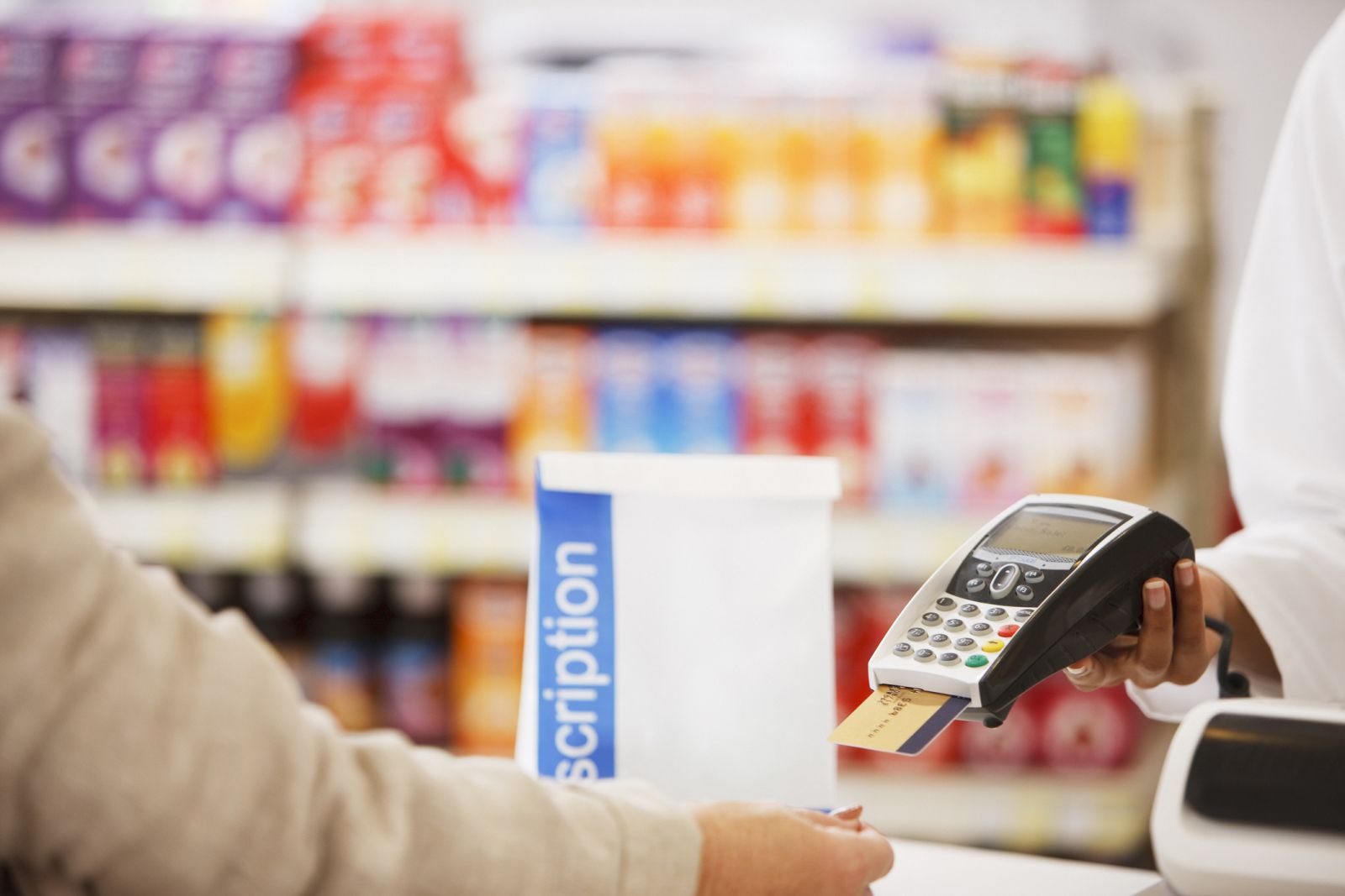 A person pays for a prescription at the pharmacy