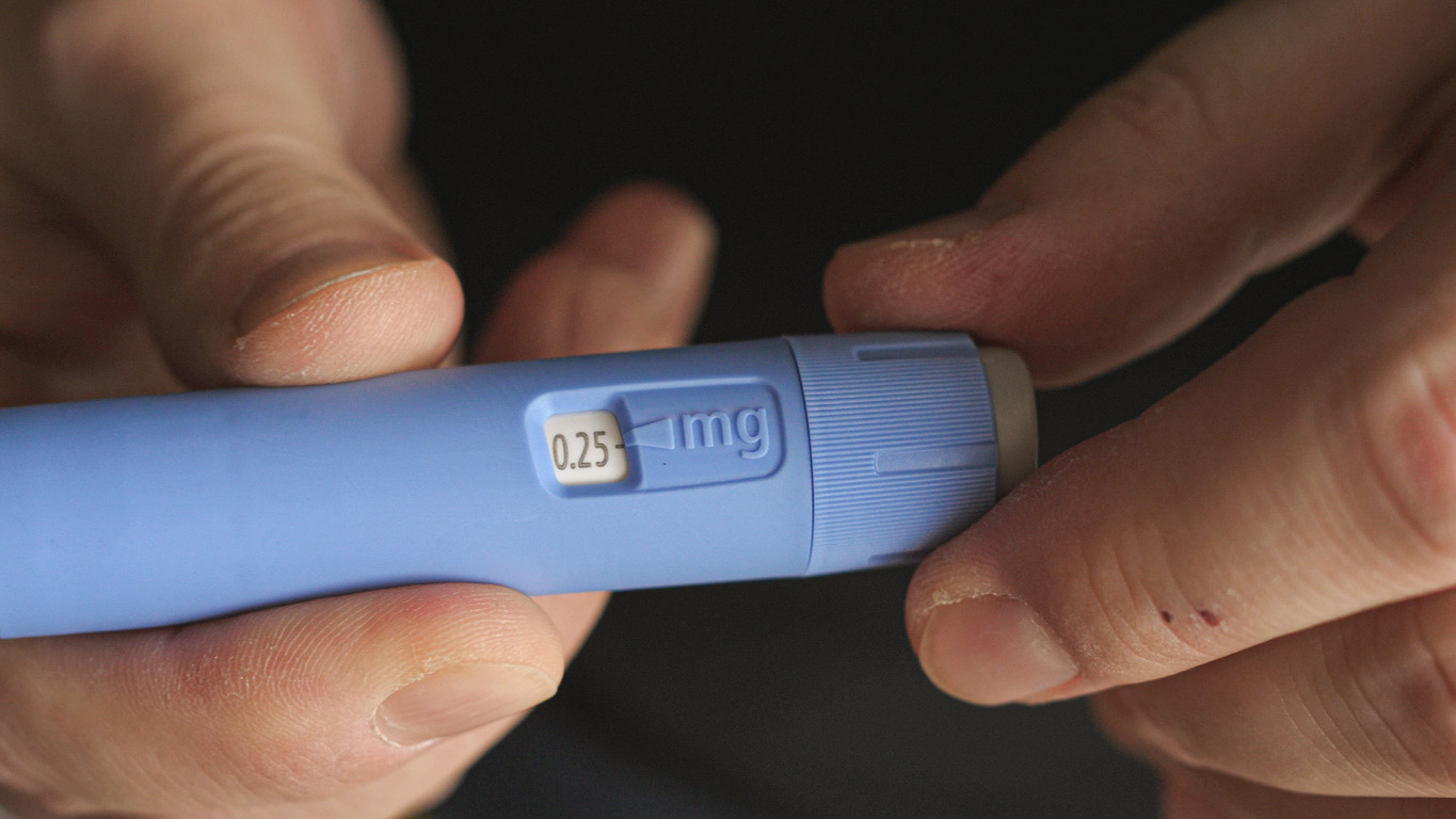 A person examines a semaglutide injection pen