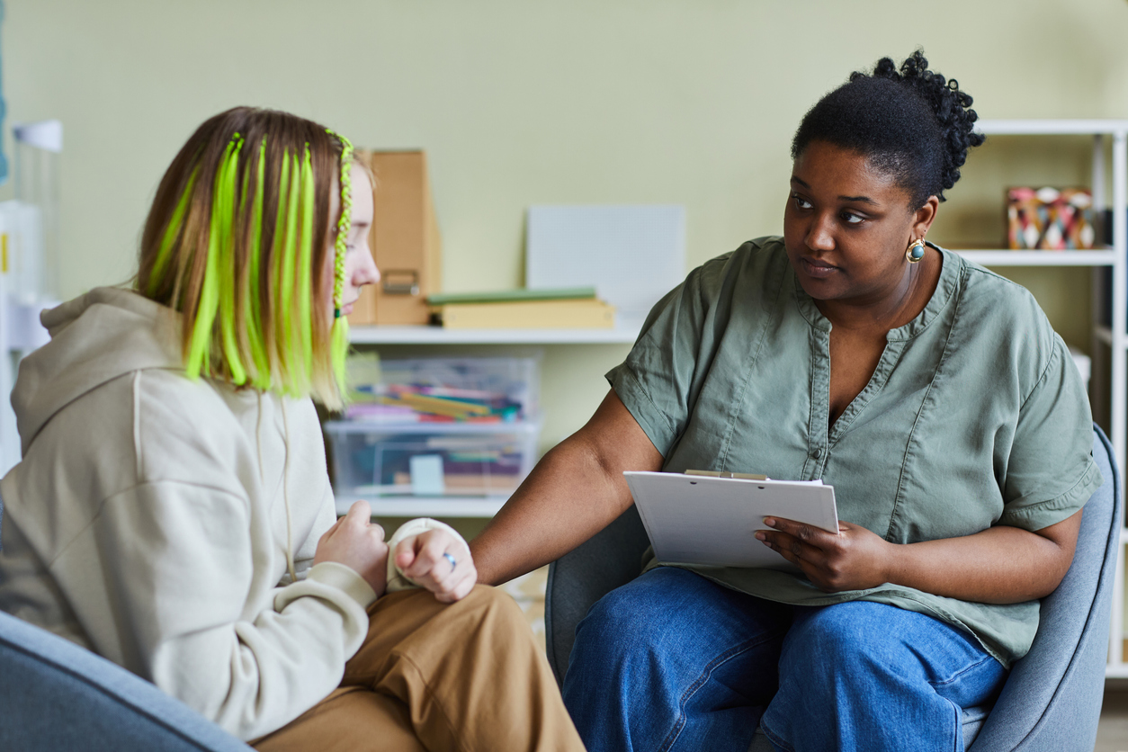 A healthcare provider comforts a girl experiencing suicidal ideation