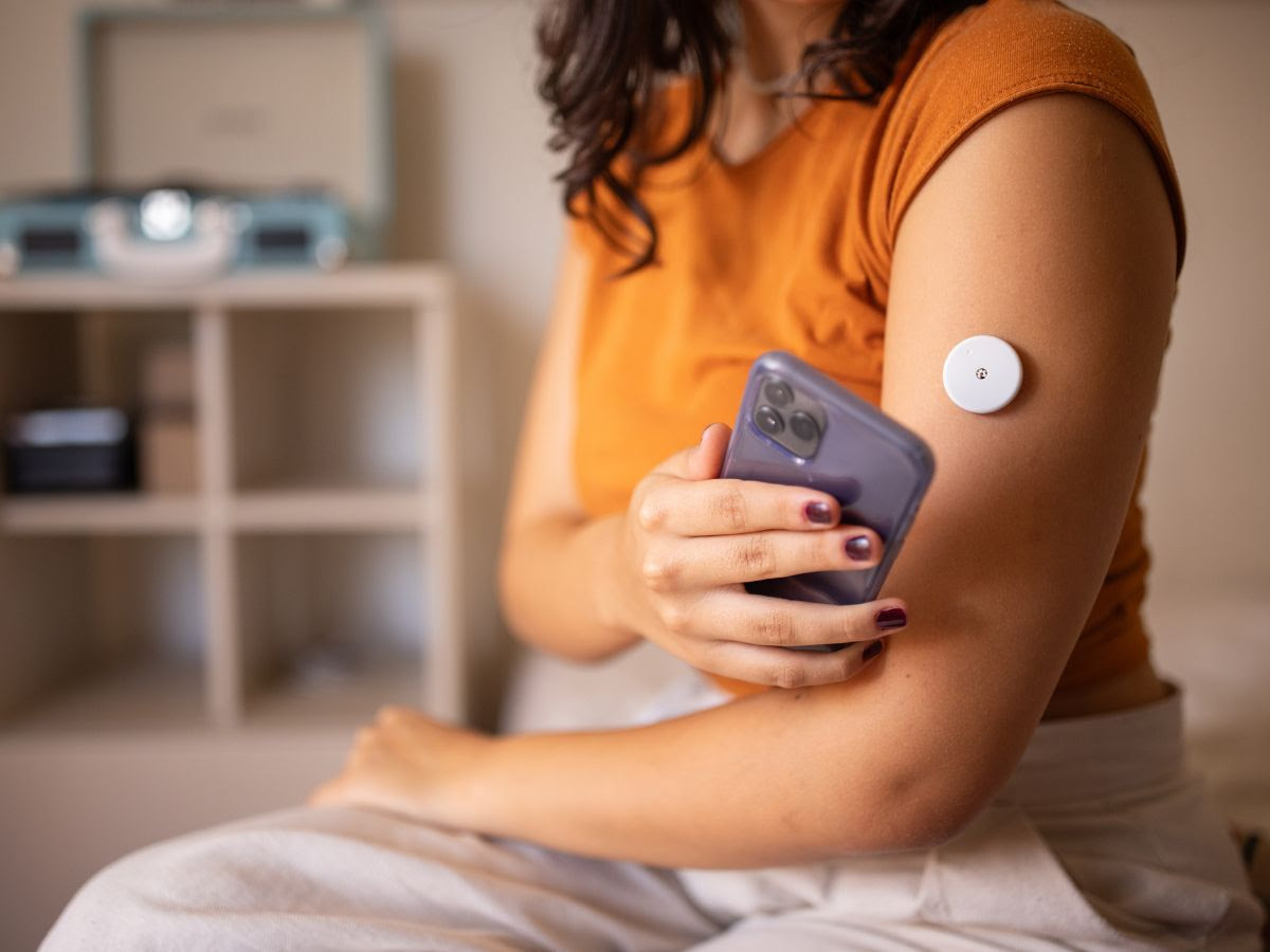 A person with diabetes uses CGM to check her blood sugar