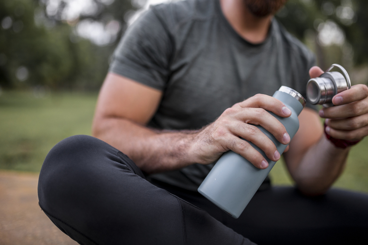 A man drinks from a water bottle