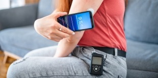 A woman with diabetes uses an automated insulin delivery (AID) system