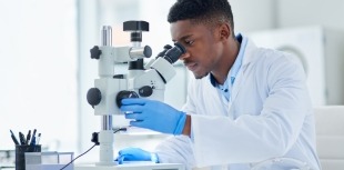 Scientist looking through microscope