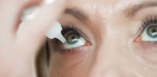 Woman putting in eye drops.