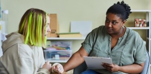 A healthcare provider comforts a girl experiencing suicidal ideation