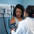 A doctor performs a blood pressure screening for a person with diabetes