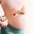 A pregnant person eating yogurt