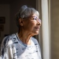 older woman looking out window