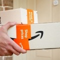 A person holds a package delivery from Amazon