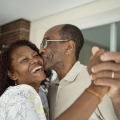 older married couple holding hands, laughing and dancing